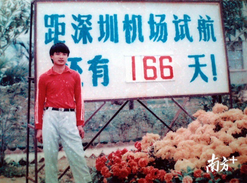 一名机场员工在深圳机场试航倒计时牌前留影。
