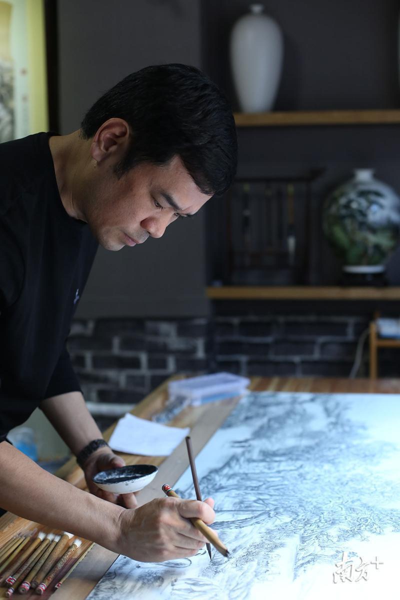 图为吴学湘在画瓷板画。