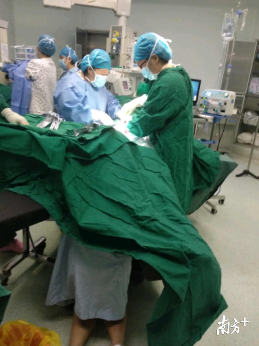 助产士在手术室跪地托住胎儿双脚，怀孕医生参与手术，多学科联动保障母婴安全。通讯员供图