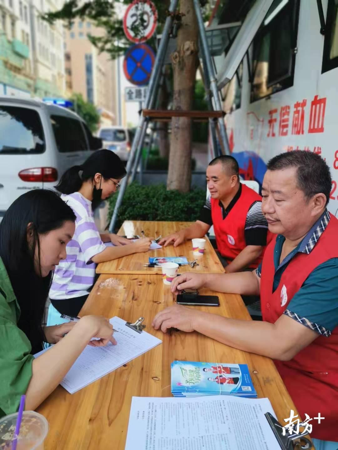 采血车前,踊跃报名献血的志愿者。 采血车前,踊跃报名献血的志愿者。