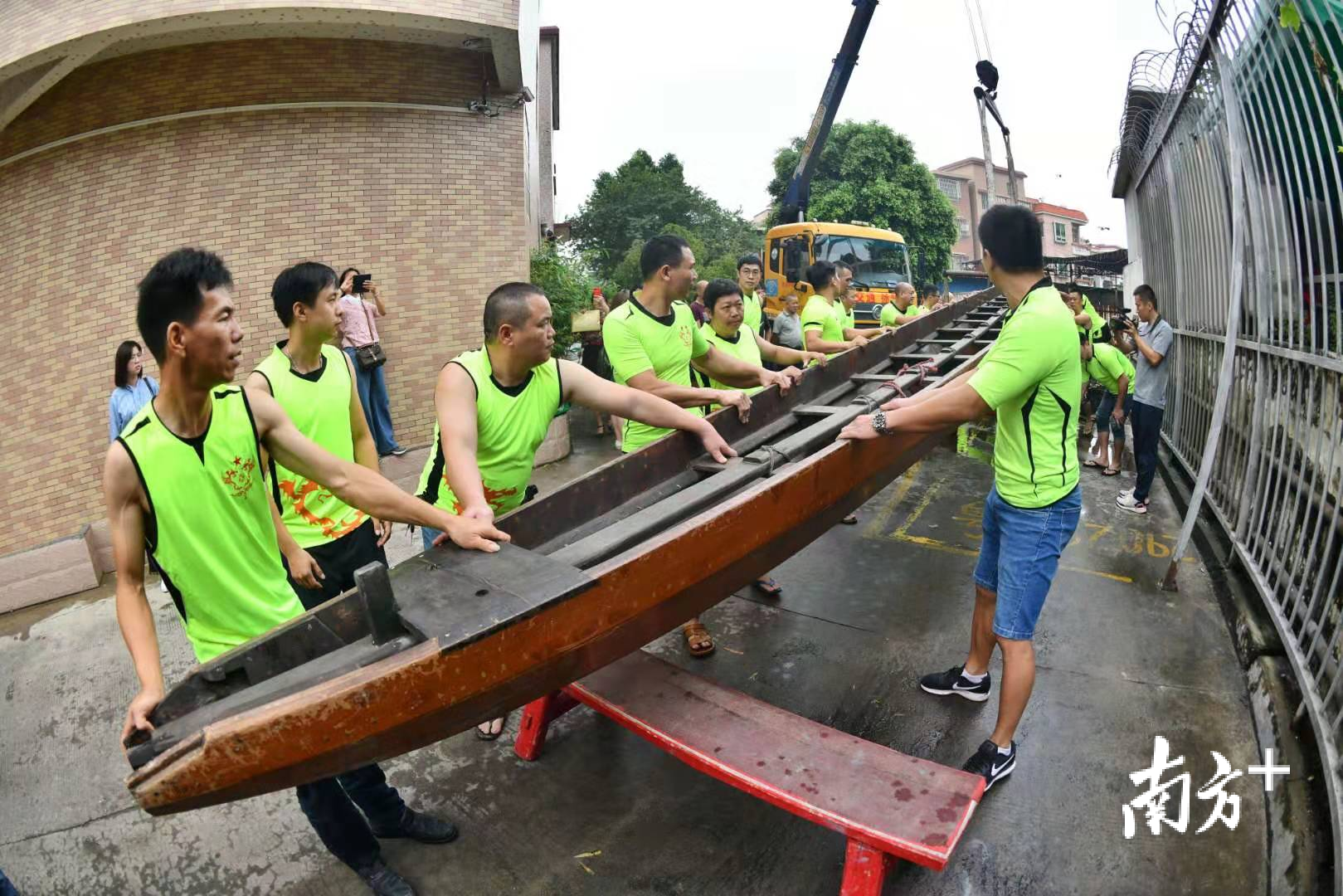 众人合力将龙船装到车上。戴嘉信 摄