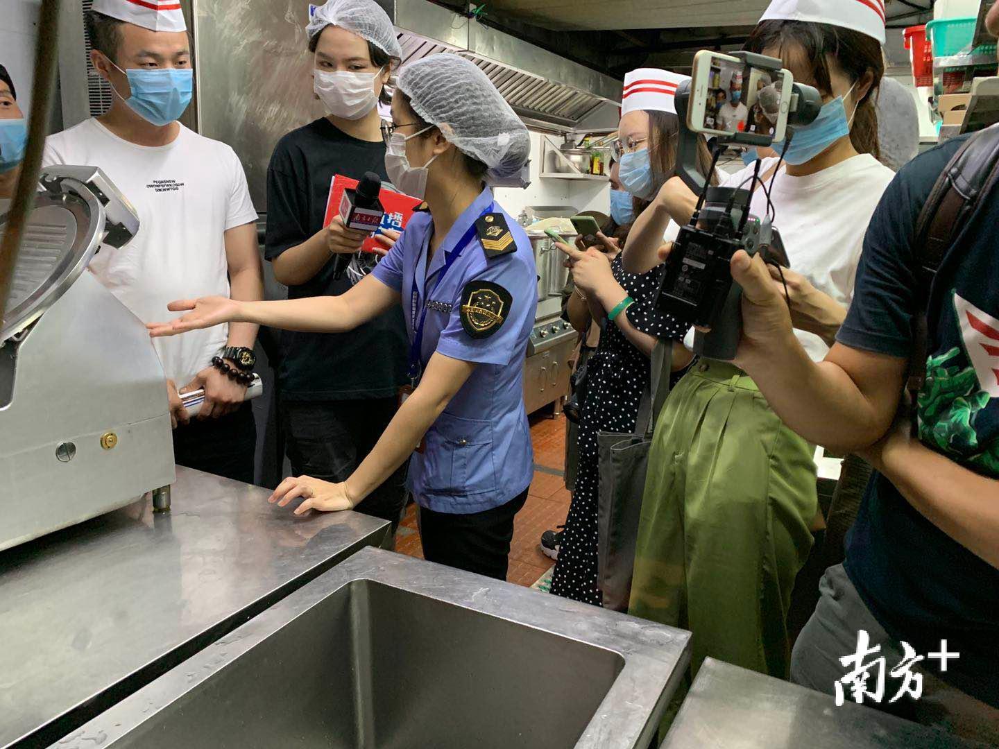 珠海市市场监督管理局的执法人员与南方+记者在蓝波斯菊进行现场检查