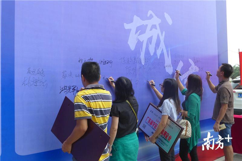 企业代表在“诚信示范街区”展板上签名。