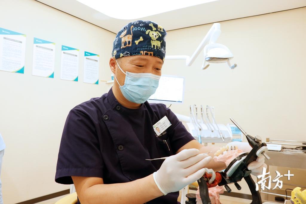解超勇正在雕牙、检查牙模。