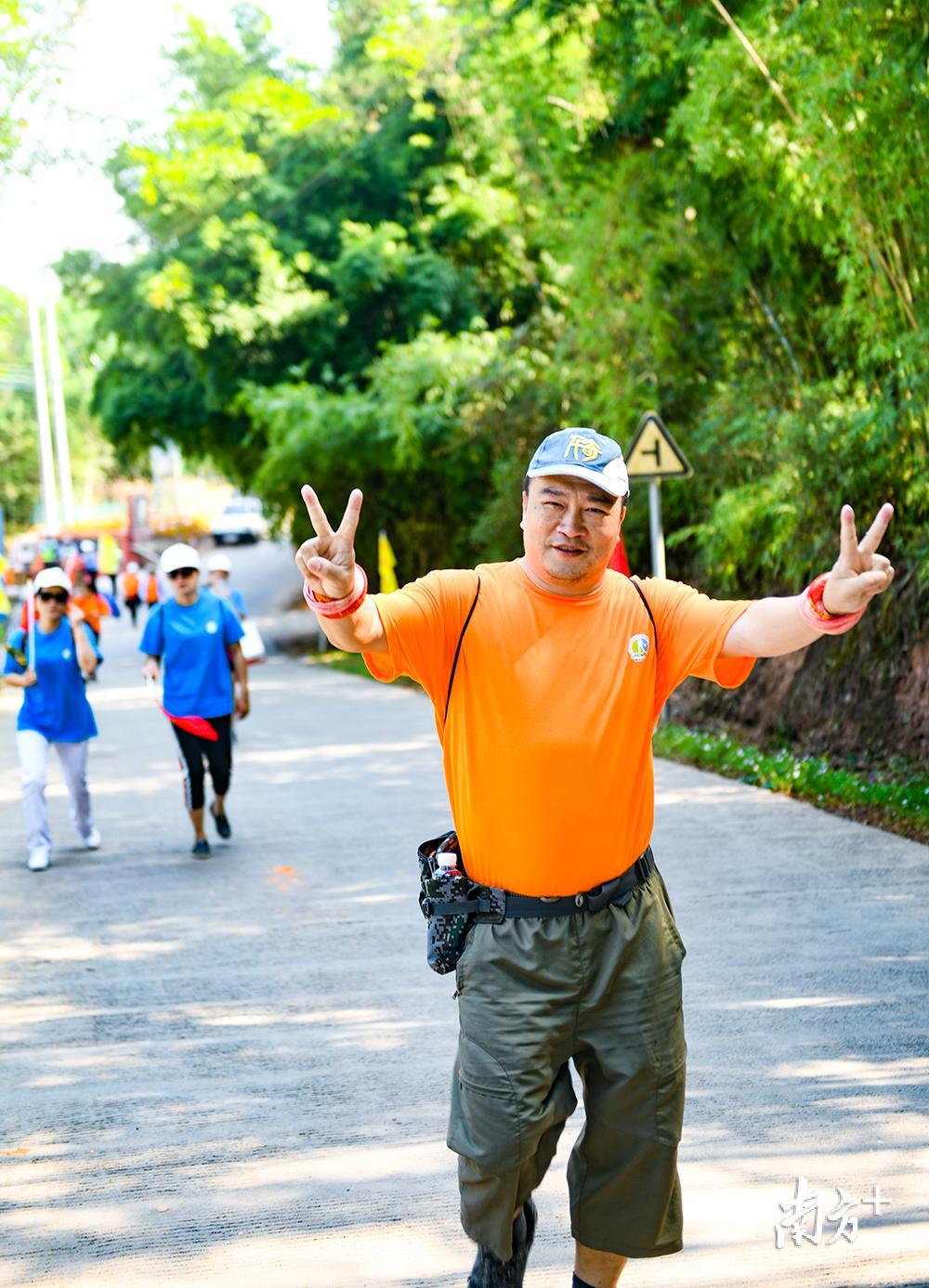 面对镜头，徒步爱好者双手比V，表达徒步过程中的快乐享受。