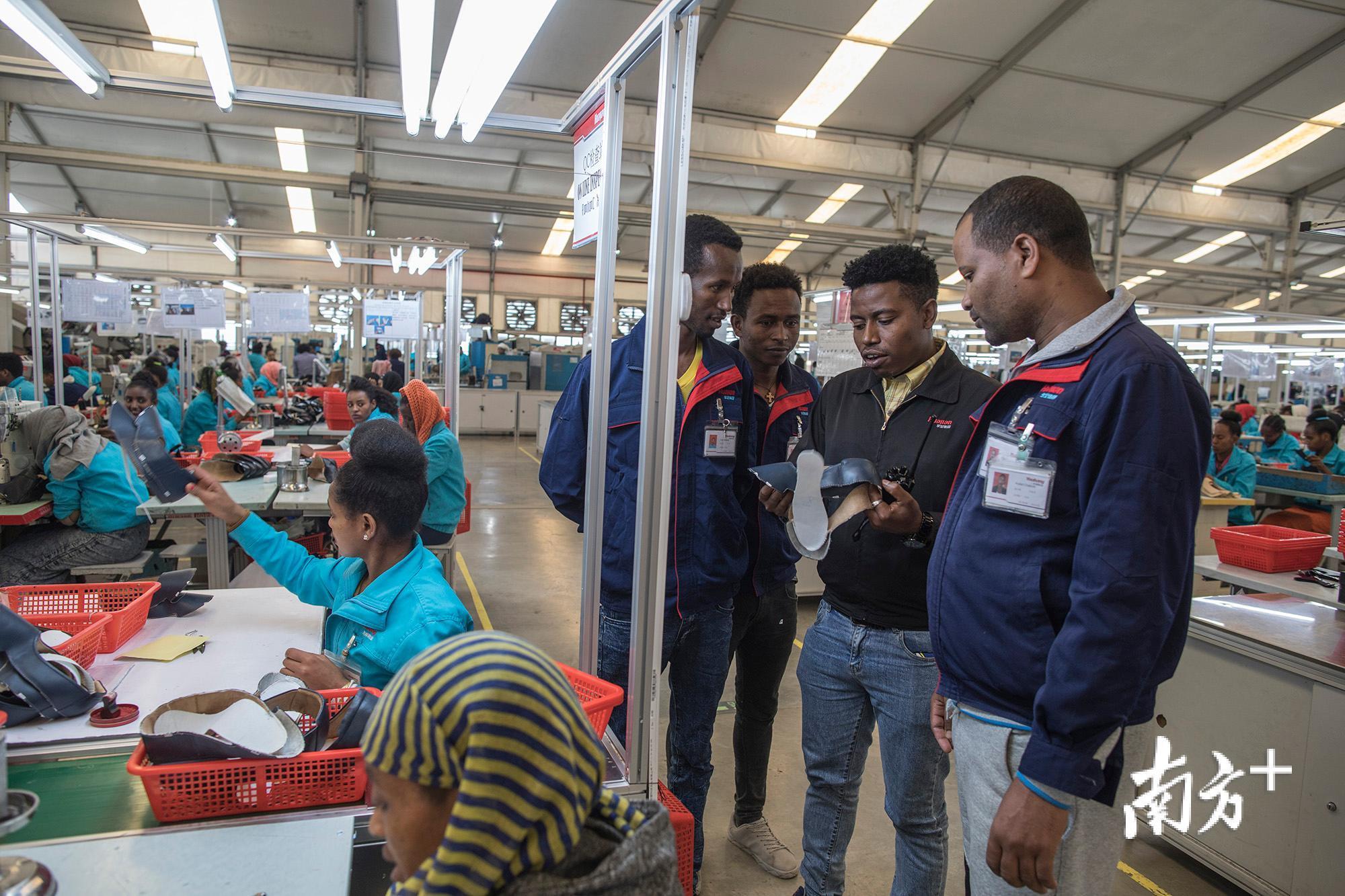 戴密斯(右二)正在与生产线的同事进行沟通,他有一个中文名叫“上海”。 戴密斯(右二)正在与生产线的同事进行沟通,他有一个中文名叫“上海”。