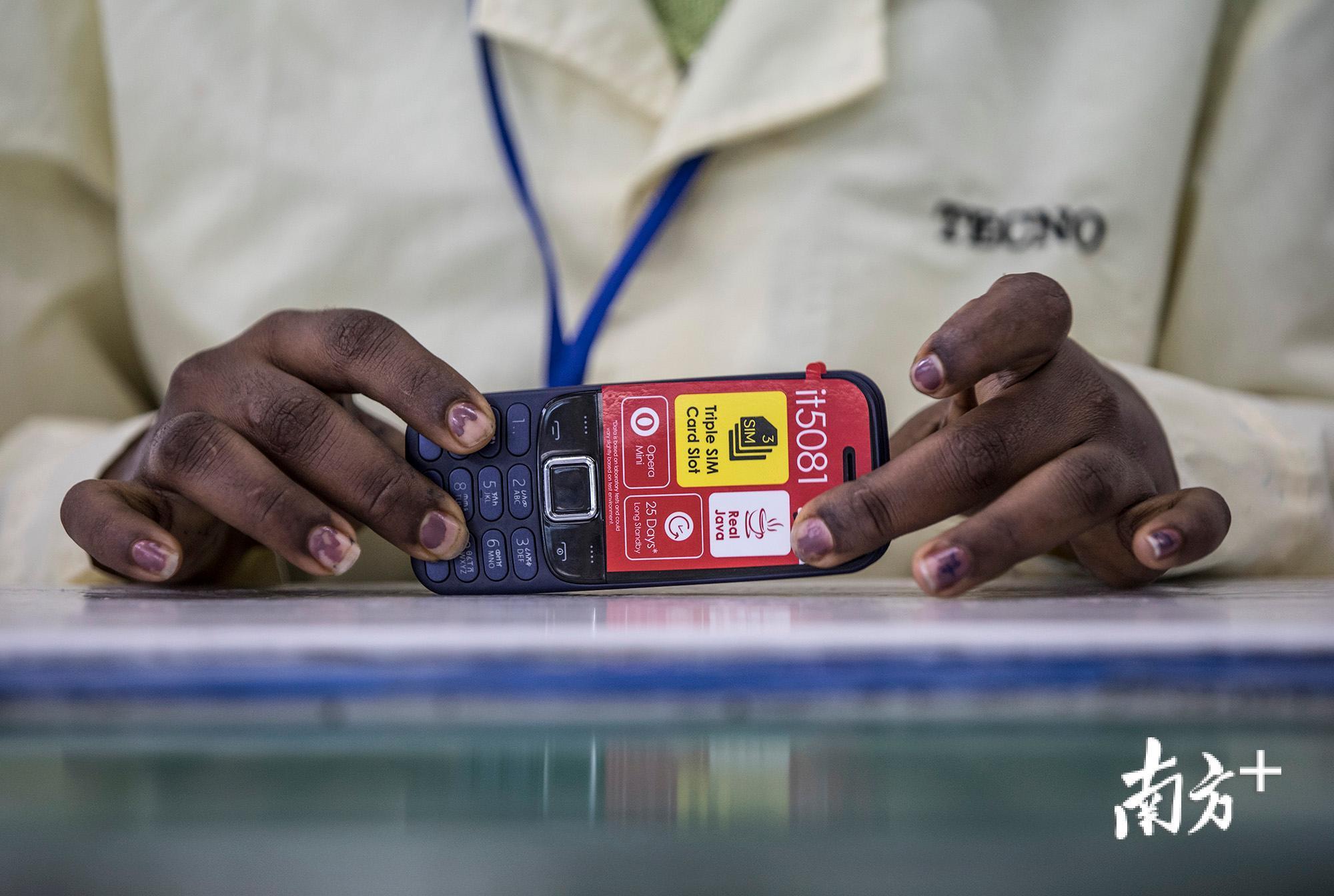 一名女工正在一台组装完毕的手机进行检测。 一名女工正在一台组装完毕的手机进行检测。