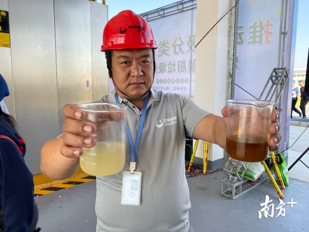 餐廚垃圾處理中心工作人員展示經(jīng)油水分離后的可回收油和水。李志穎 攝