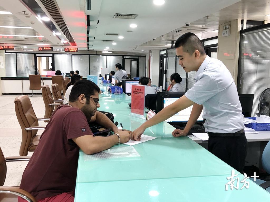 工作人员热心引导外籍人员填写资料。