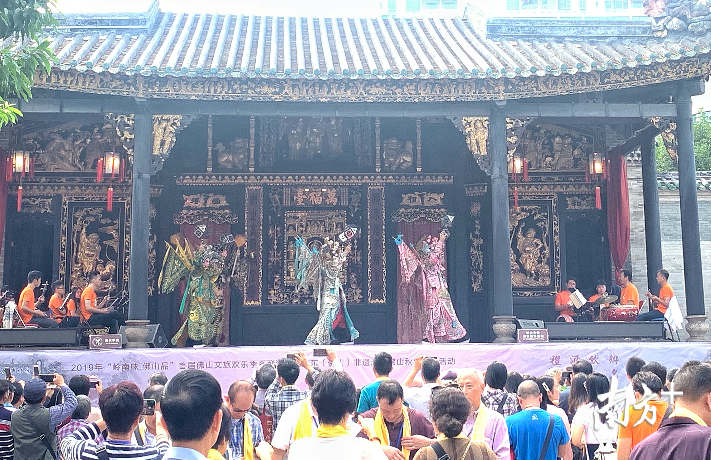 游客在万福台前观看粤剧展演。庄晓莹 摄 游客在万福台前观看粤剧展演。庄晓莹 摄