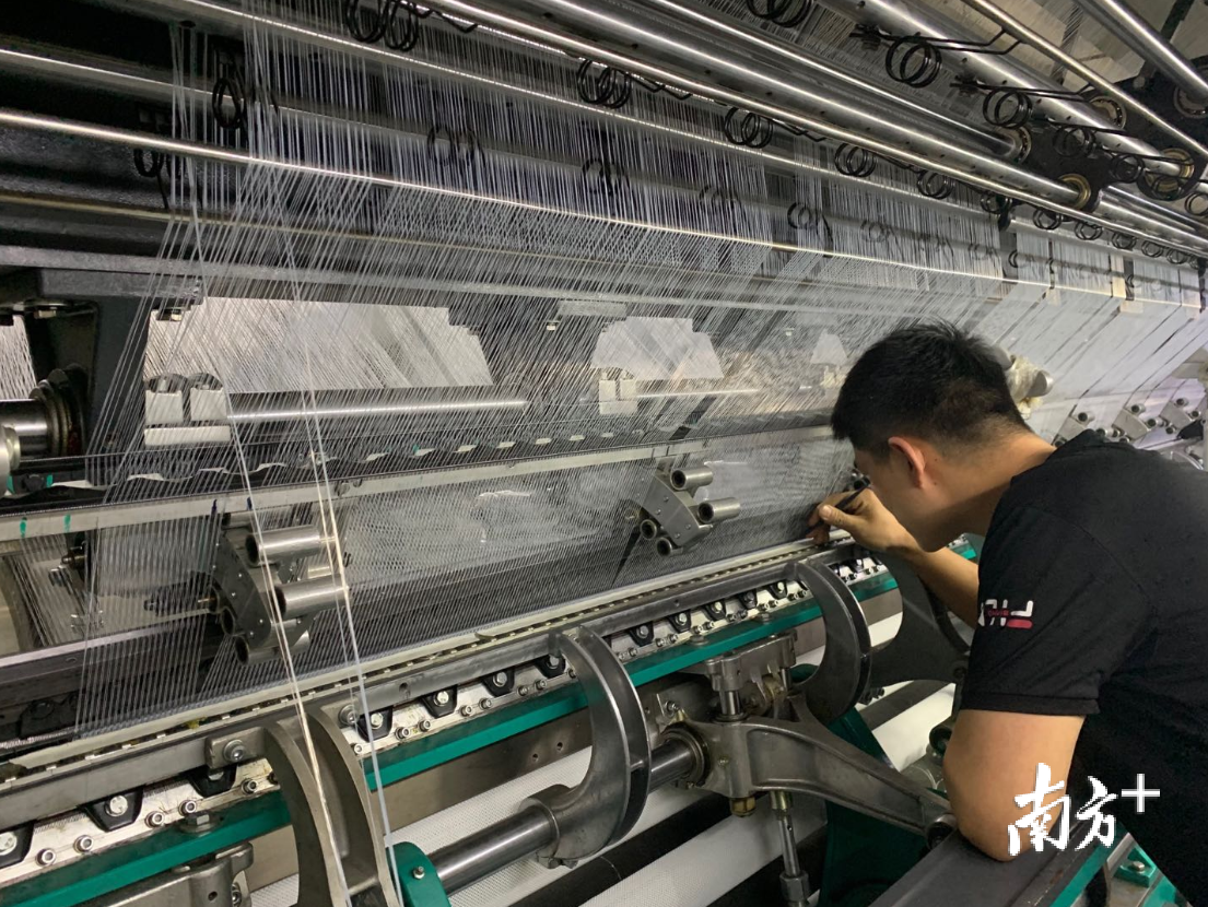 信泰工厂自动化设备边,工人检查纱线。王蓓蓓 摄 信泰工厂自动化设备边,工人检查纱线。王蓓蓓 摄