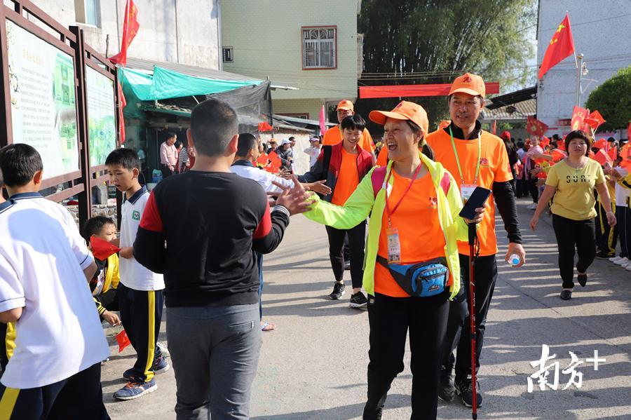 图为小朋友们夹道欢迎徒步者的到来。