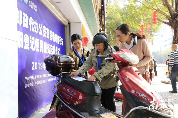 市民在邮政网点办理电动自行车注册登记。 段灿 摄