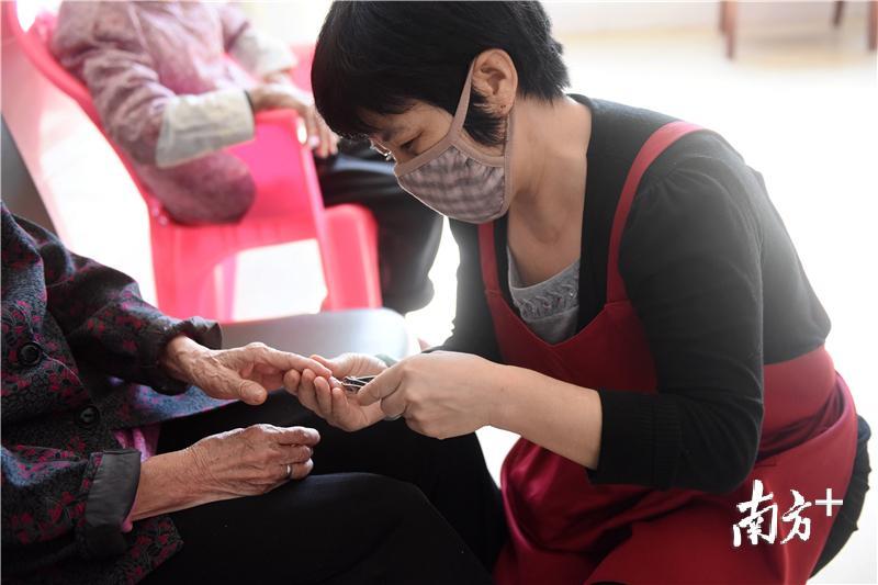 惠州市怡安养老院的护理员帮老人修理指甲。