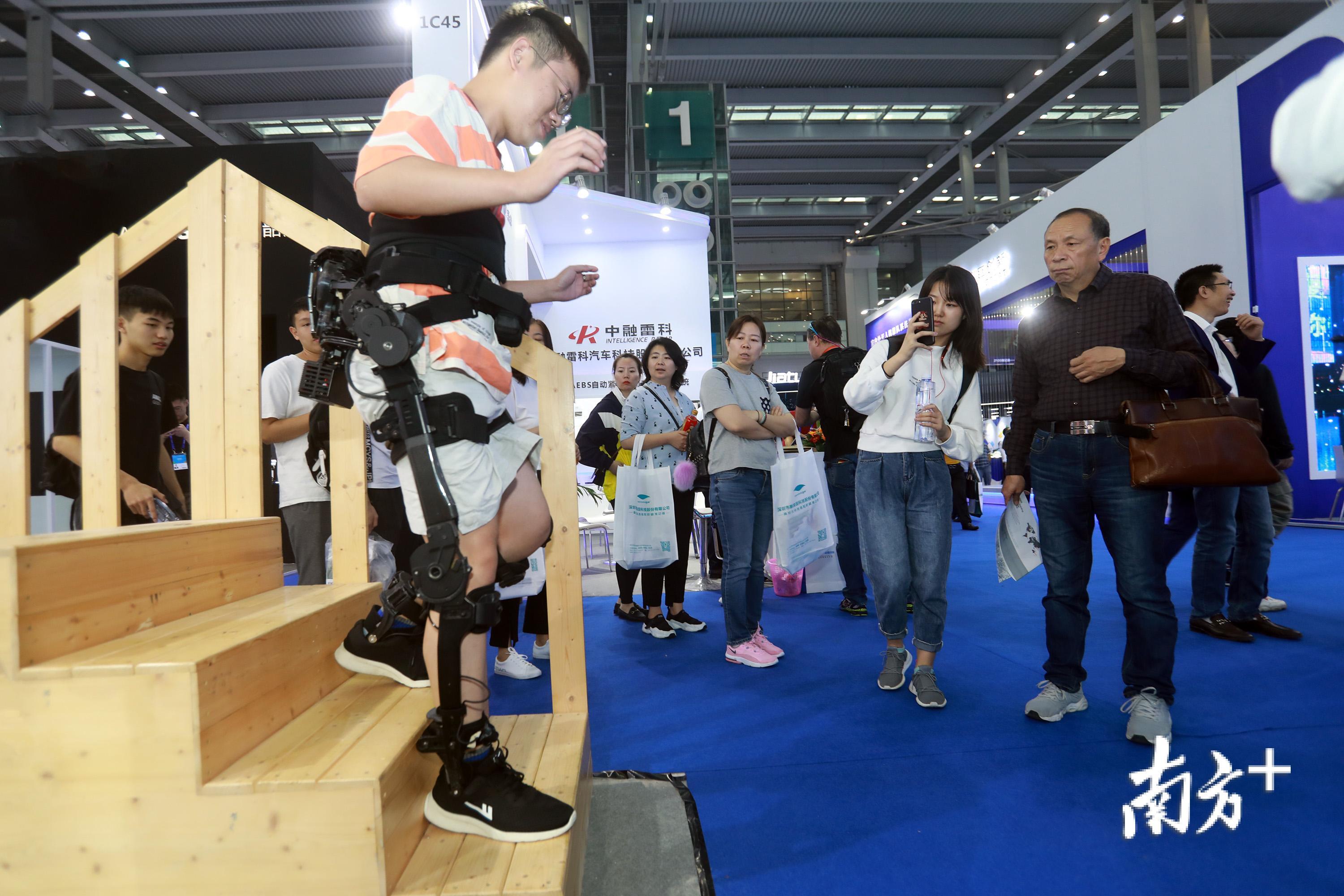 观众正在体验可穿戴外骨骼机器人。