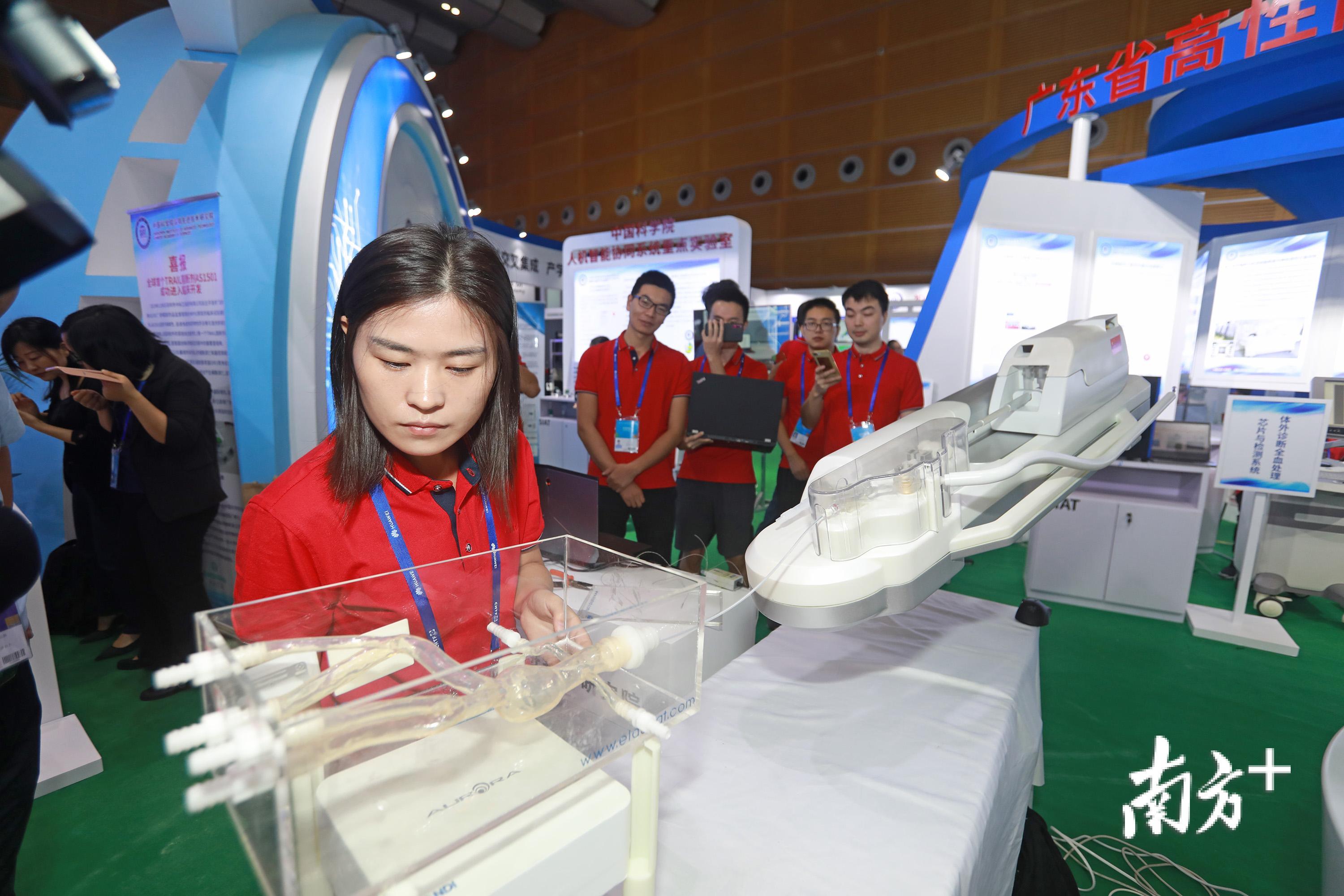 工作人员正在演示一台血管介入手术机器人。