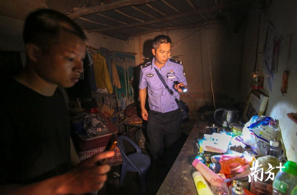 柯广谋（右一）在电信诈骗犯罪嫌疑人家中搜索证据。林继健 摄