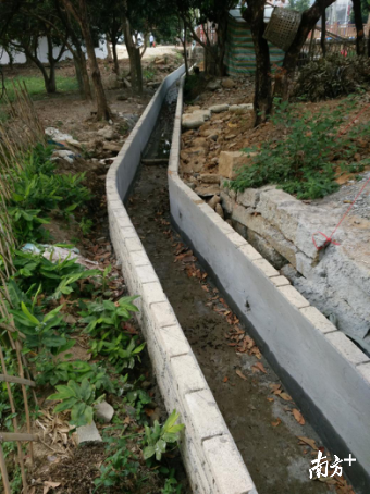 护南村在水沟两边砌砖，解决楼房卫生间排污问题。