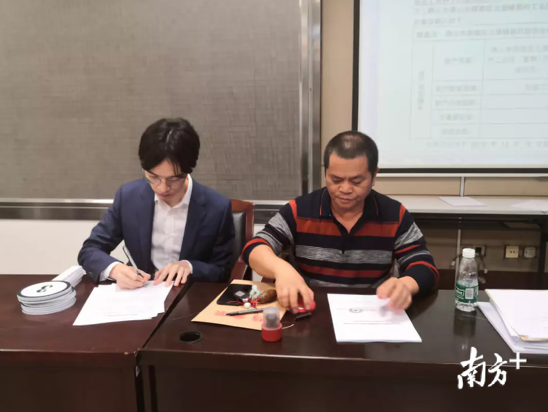 佛山市博景宸产城发展有限公司代表郑超殿（左）和桃村股份合作经济社理事长袁锐文（右）现场签署成交确认书。顺德村改办供图
