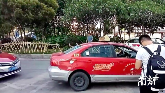 在金融高新区A出口附近，停靠了三四辆出租车，均为“待租”状态。汤晓微摄