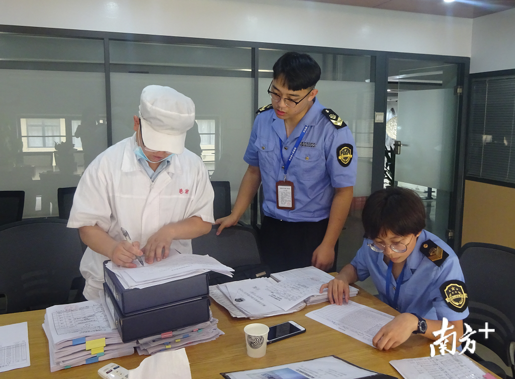 南海区市场监督管理局执法人员正在检查食品生产企业台账。南海区市场监督管理局供图