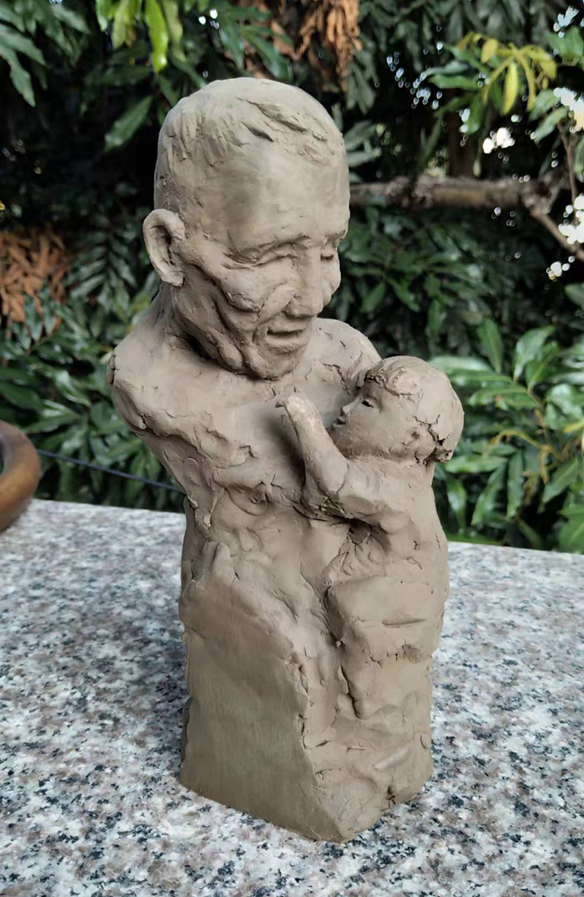 这件名为《寄望与传承》的泥塑作品，是卢邓发献给已逝父亲的礼物。