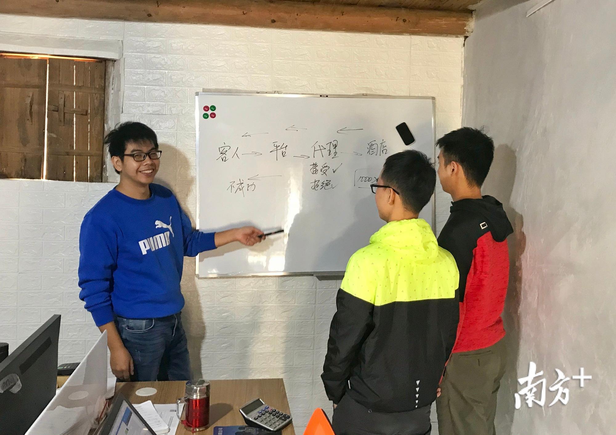 丘久锋（左一）正与团队成员交流探讨问题。