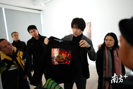 李昊在向大家展示用李志良作品二次创作的T恤