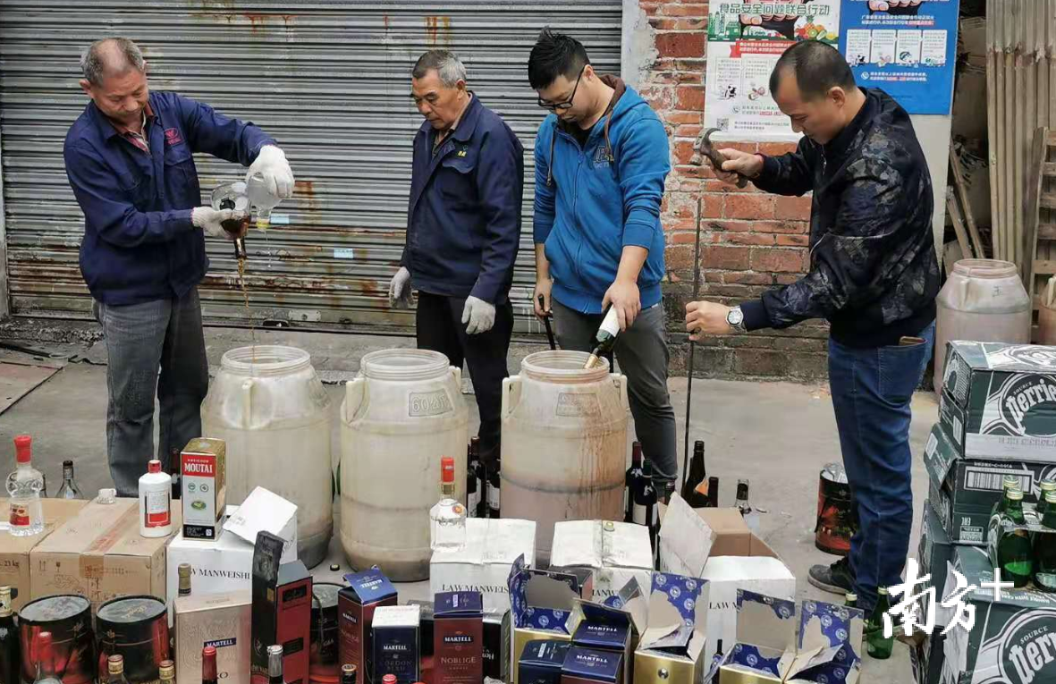 工作人员正在销毁假酒。 工作人员正在销毁假酒。