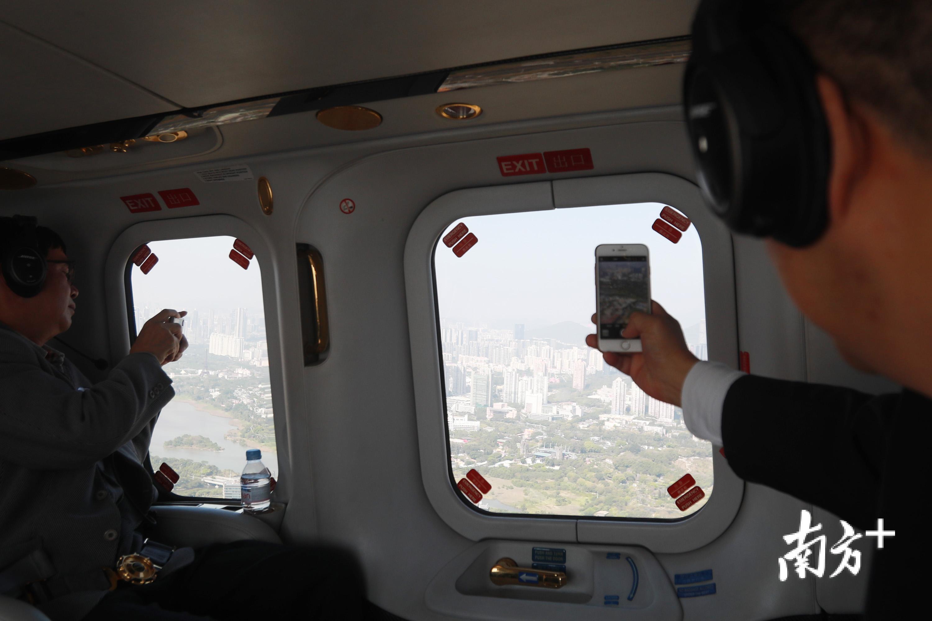 乘客用手机拍摄城市景观.