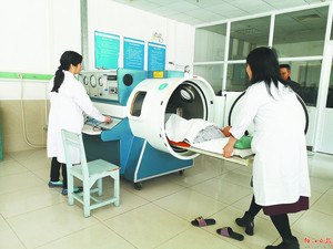 小斌躺入高压氧舱准备接受治疗。简梅芳 摄