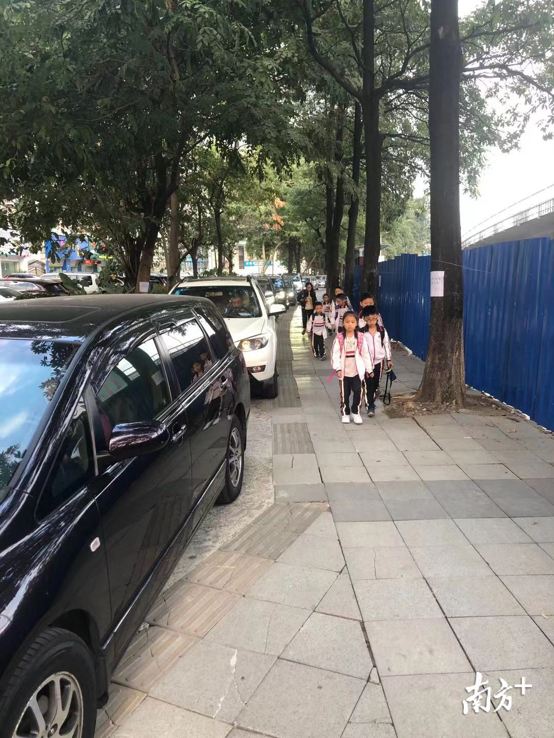 11月25日，在江南世家和宏远桥之间，由于堵车被耽误上学的孩子们只能提前下车，和车辆并肩前行赶往学校。