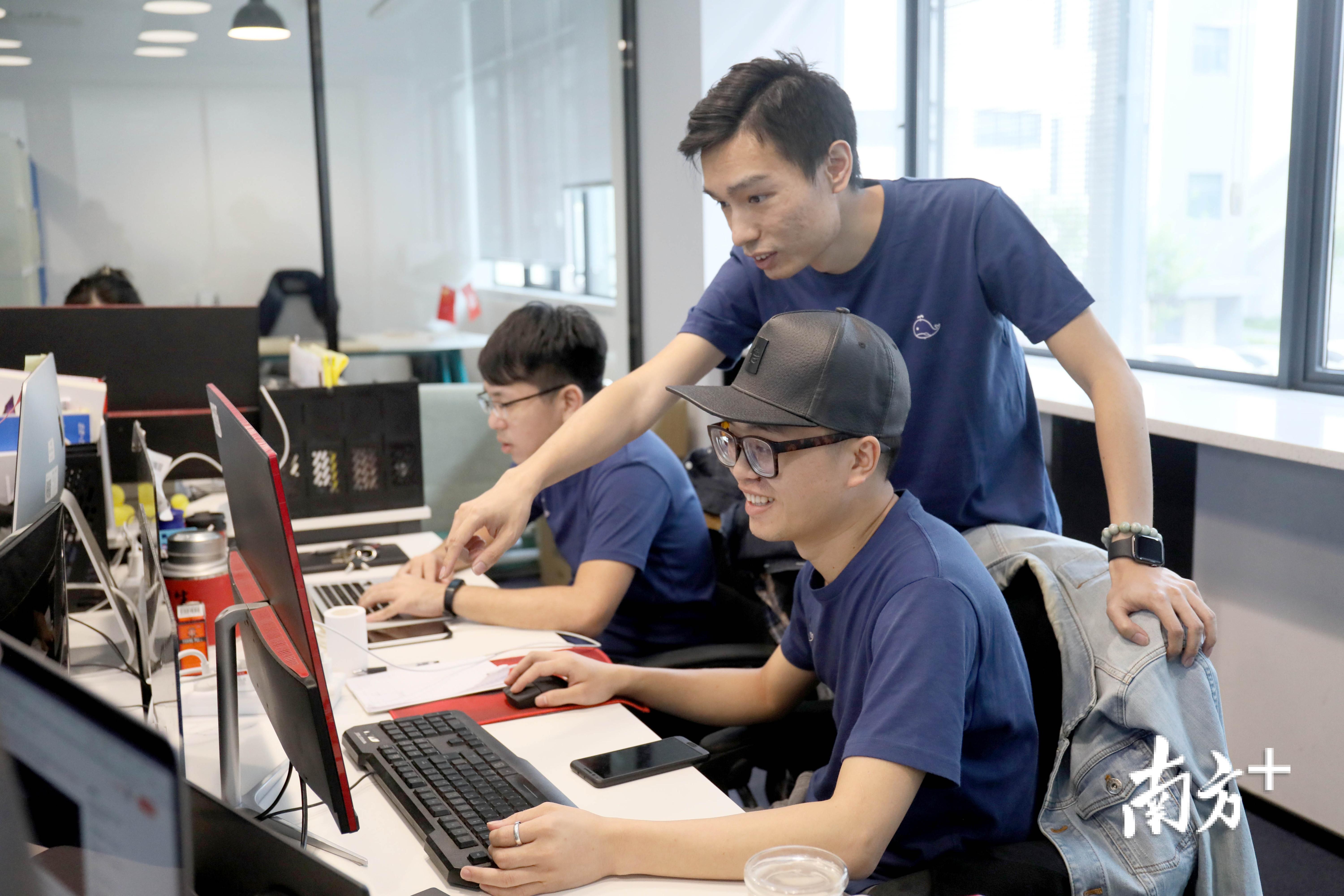 香港创业青年刘加传(中)与创业伙伴讨论工作 香港创业青年刘加传(中)与创业伙伴讨论工作