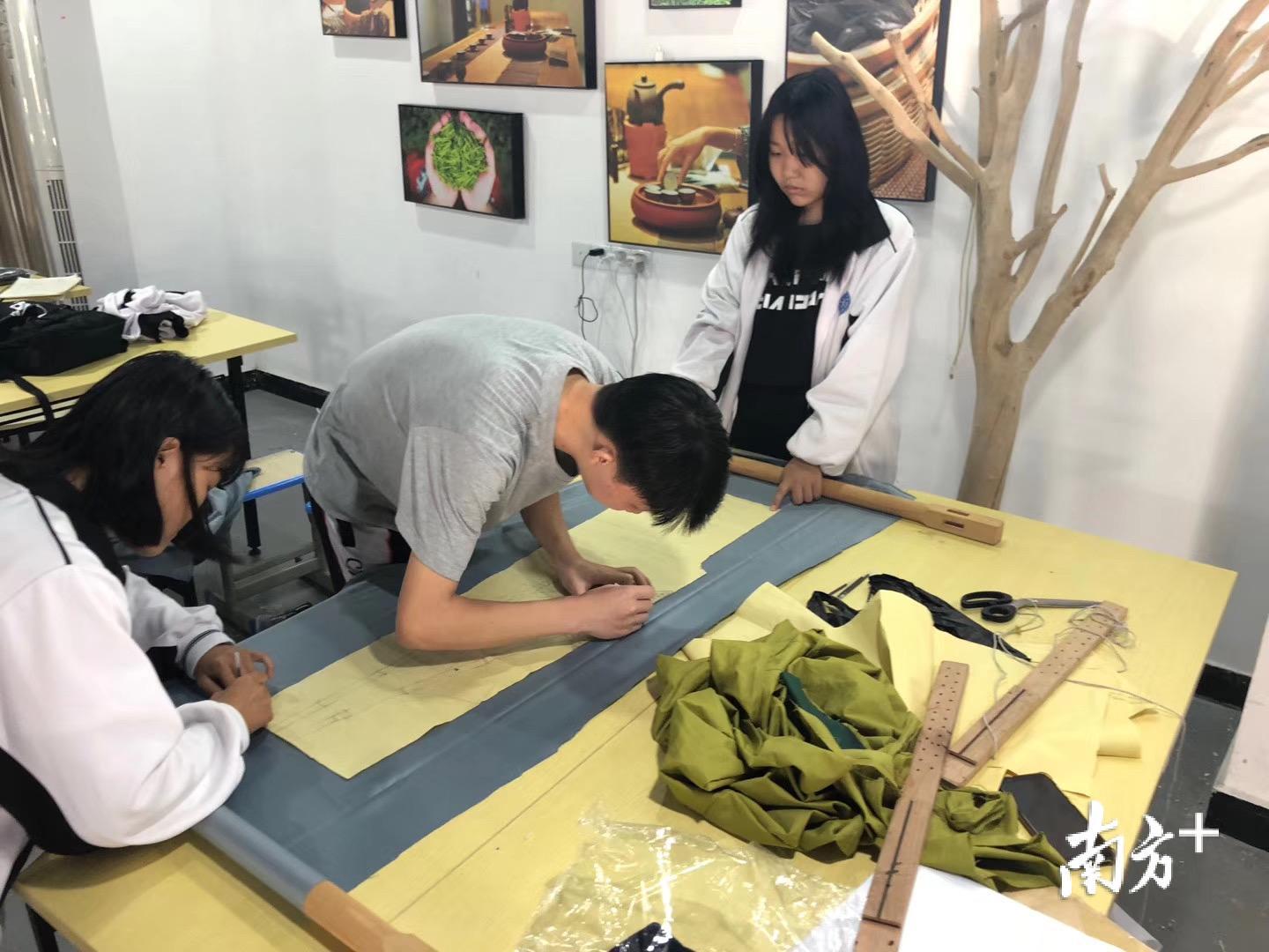 罗潮政(中)在赶制潮绣元素的时装作品。 罗潮政(中)在赶制潮绣元素的时装作品。