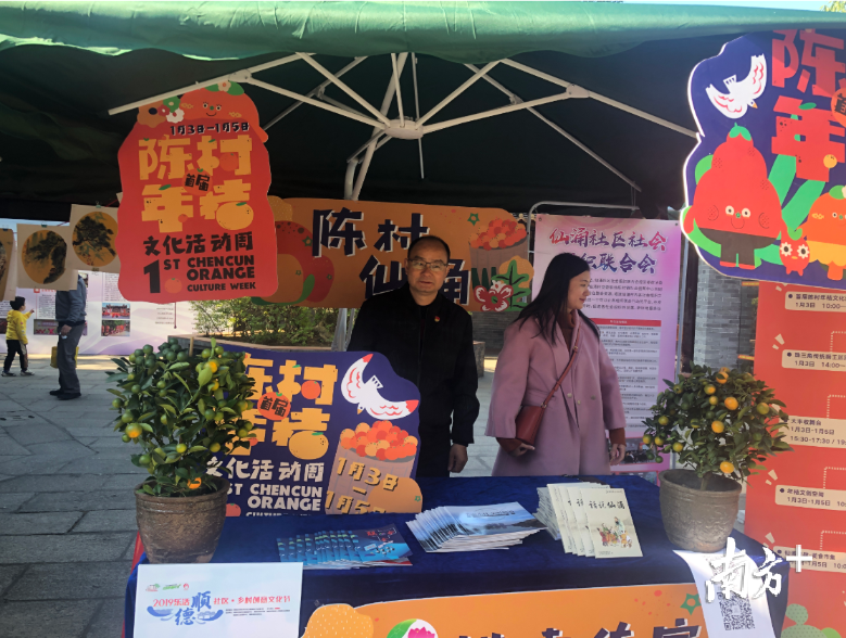 陈村镇仙涌村党委书记何永坚（左）来到摊位前为陈村年桔代言。