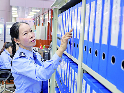 冯晓梅在业务窗口查看档案资料。西江日报记者 吴威豪 摄