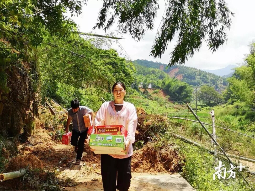 在组织村民转移过程中摔伤右手的唐莉，仍坚持搬运爱心物资。