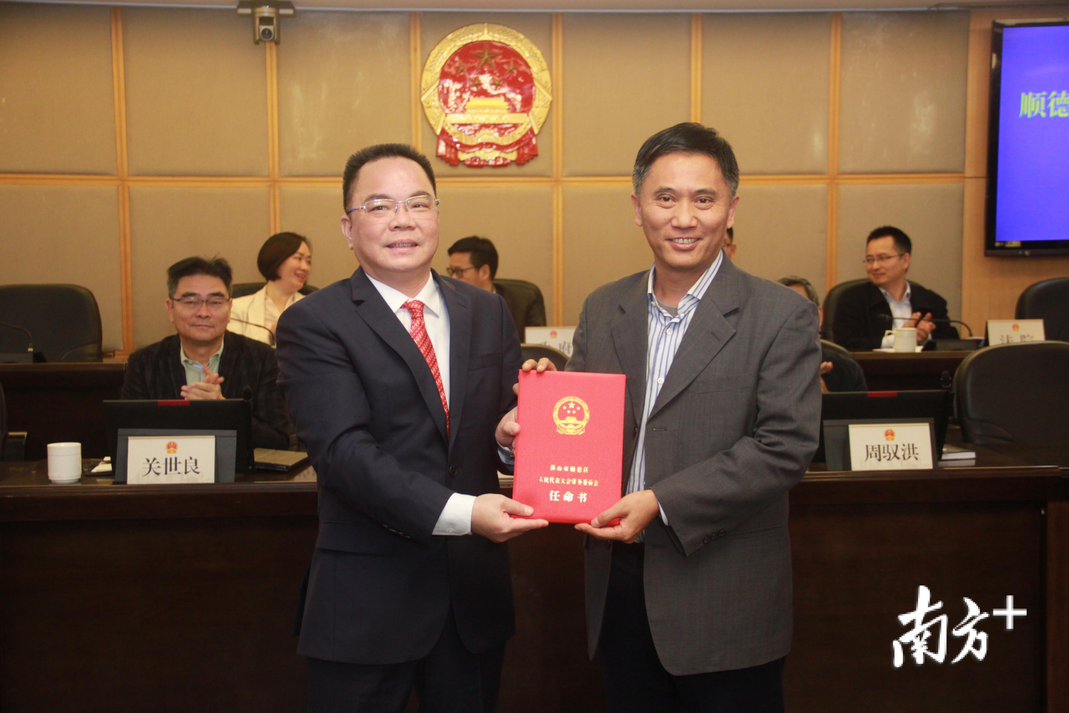 顺德区人大常委会党组书记、主任列海坚（右）为新任命的刘国兴（左）颁发任命书。欧阳少伟 摄