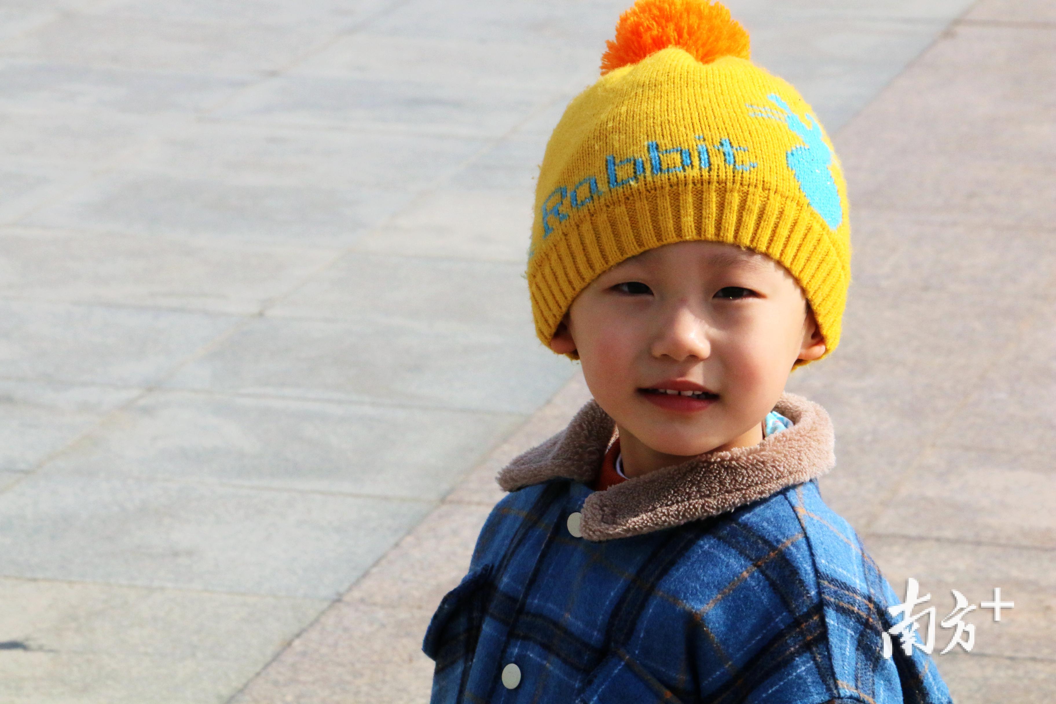 一名小男孩在妈妈的陪同下晒着太阳。