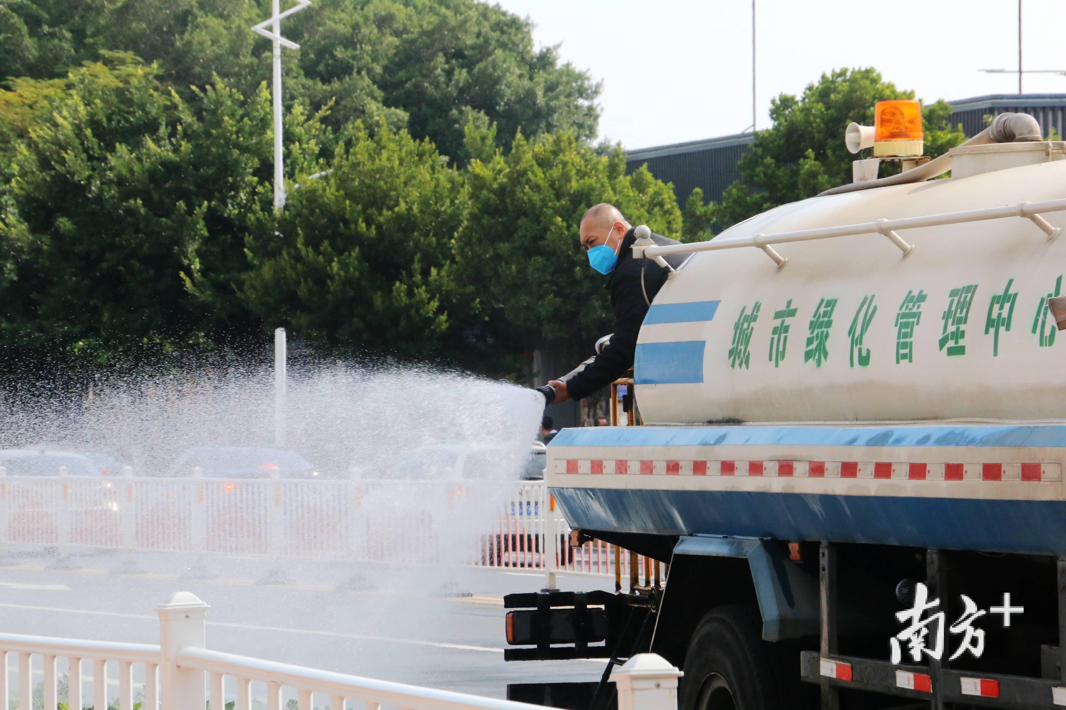 沿路灌溉花草的城绿工人。