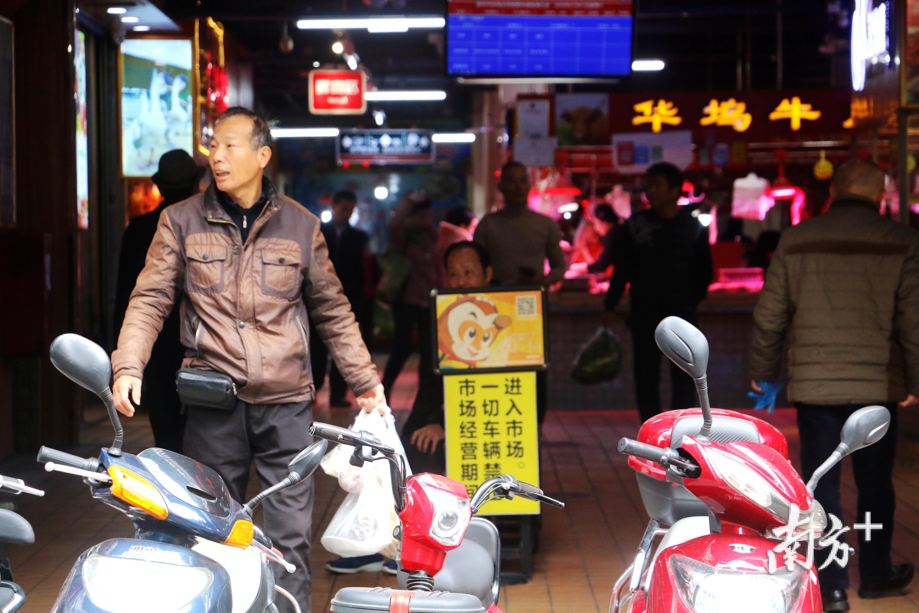 从新华坞市场买菜出来的市民。