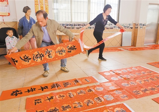 写好的春联铺了一地，村民喜笑颜开。