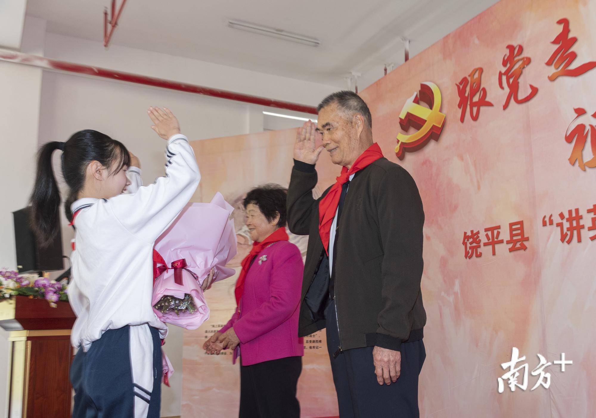 少先队员向麦贤得伉俪献上鲜花。