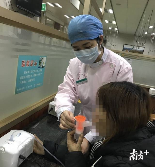 禅城区人民医院护士钟永红在帮助患者做雾化治疗。