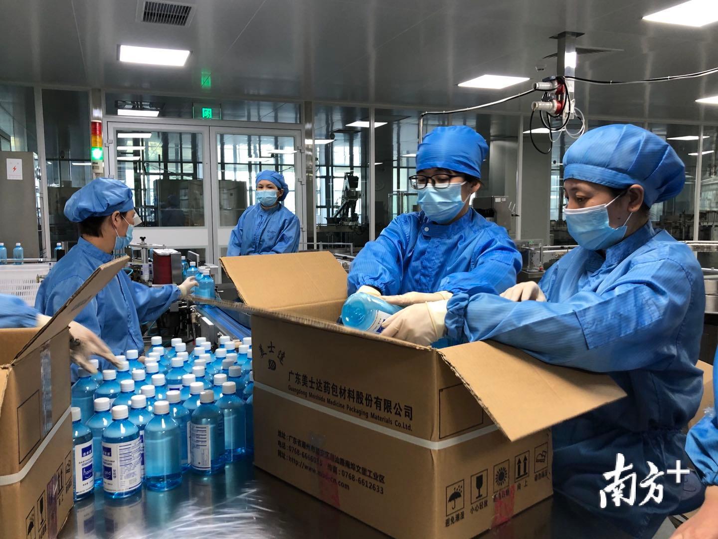 工人们在传统直线灌装车间内做最后的包装.