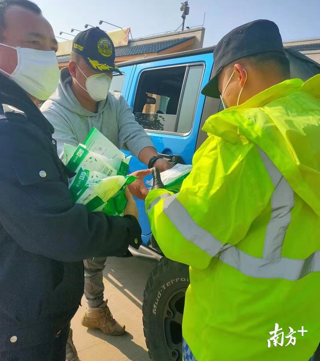 热心群众为检查站执勤人员送口罩。 热心群众为检查站执勤人员送口罩。