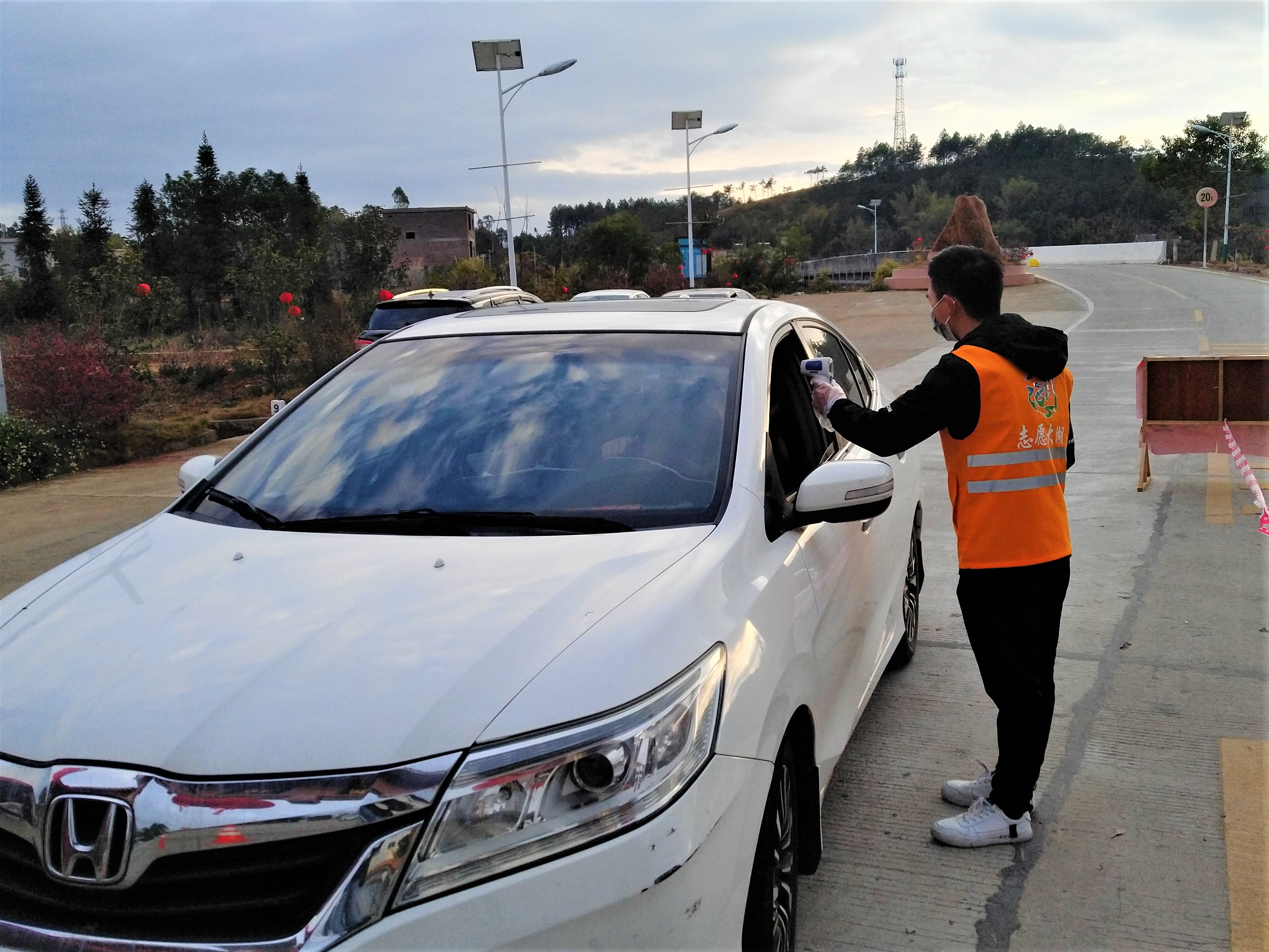 志愿者检测进村司机体温。