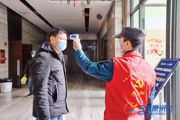 惠城区桥东街道中海水岸城小区保安为进入小区的业主量体温。 惠州日报记者汤渝杭 摄