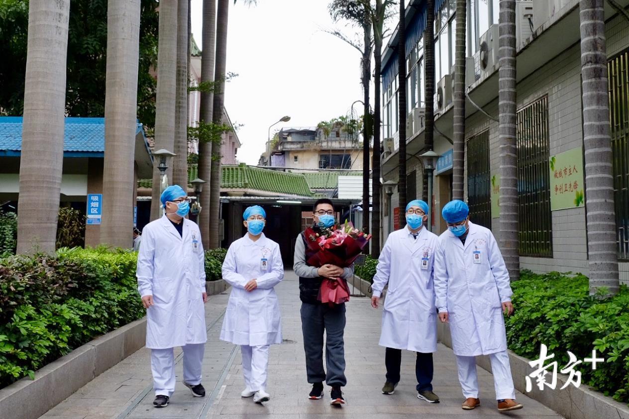 医护人员陪同梁先生走出医院。