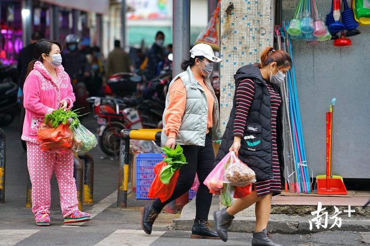 市民们采购肉菜后匆匆离开市场.梁素雅 摄